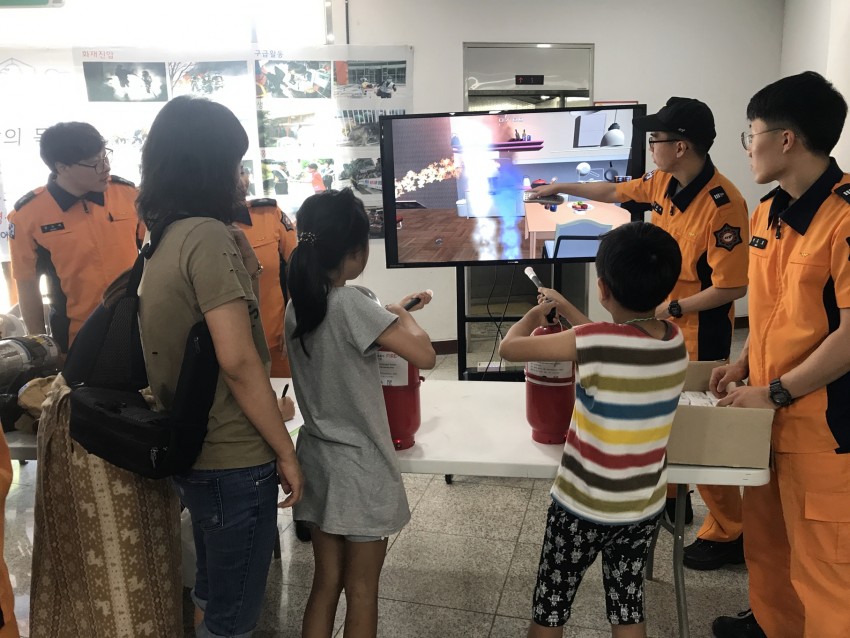 용인소방서에서 운영하는 119체험코너에 가족단위 참가자들이 방문해 가상화재 진압체험을 하고 있다..JPG